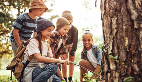 Groep leerlingen met een stok op zoek naar de natuur. - Oxtarn Natuur Excursie