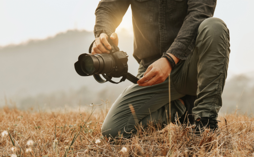 Man met spiegelreflex camera in het bos van Castricum tijdens een clinic natuur fotografie. - Oxtarn Clinics & Adventures