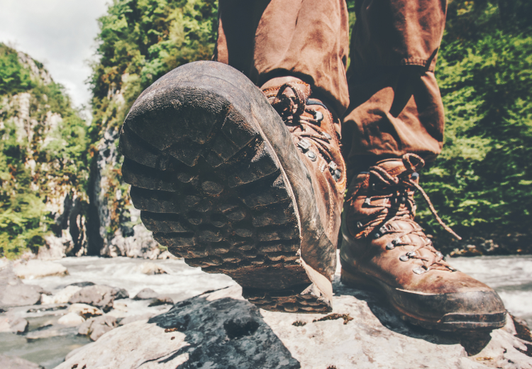 Voetstap in wandelschoenen op een heftstgrond tijdens de natuur wandelingen en wandeltochten door Castricum. - Oxtarn Clinics & Adventures